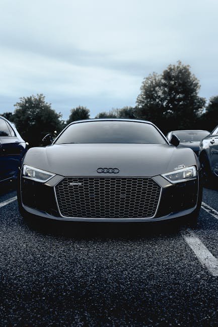 A modern Audi R8 car is prominently displayed in an outdoor parking lot, showcasing its sleek design.